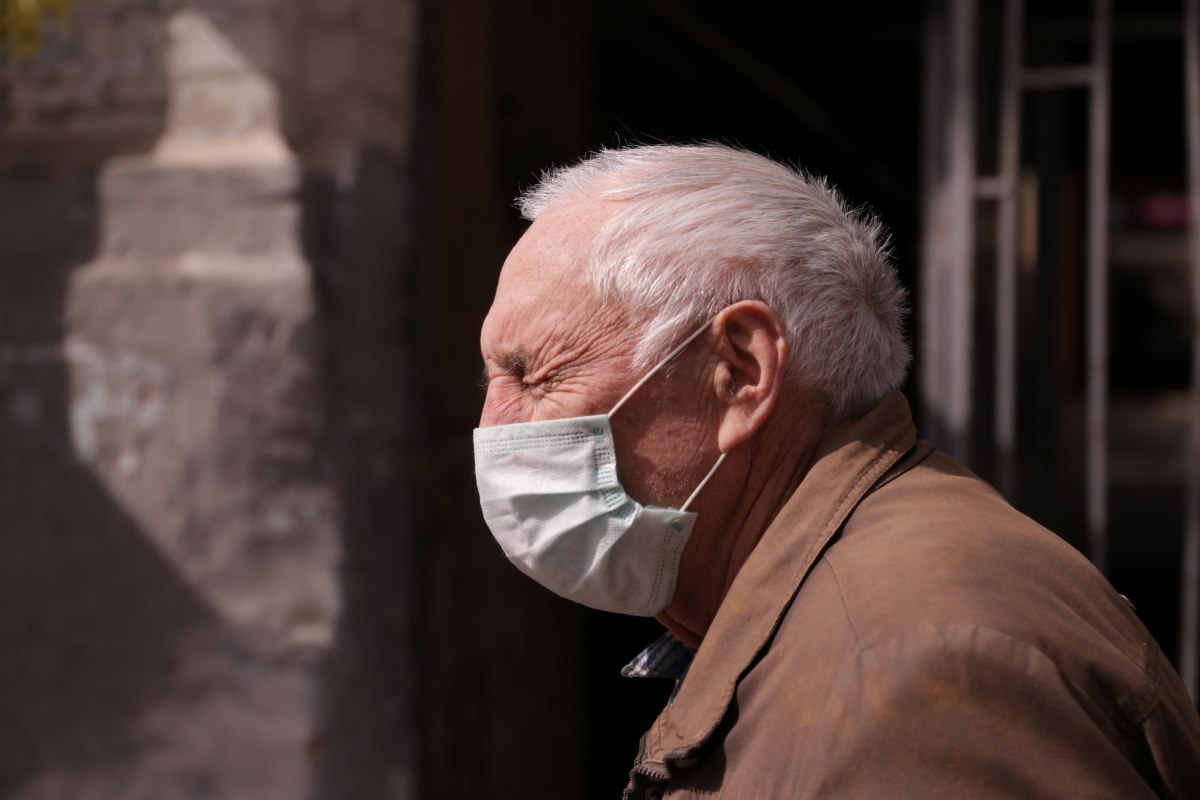 Літній чоловік, пенсіонер у захисній медичній масці